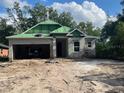 Under-construction single-Gathering home featuring a two-car garage, block construction, and green roof wrap at 25122 Ensley Rd, Sorrento, FL 32776
