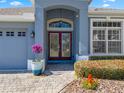 Front entry with double doors, arched entryway, and landscaping at 33931 Terragona Dr, Sorrento, FL 32776