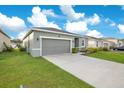 Gray house with a two-car garage and a well-maintained lawn at 3482 Forster Ave, Leesburg, FL 34748