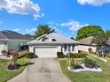 Beautiful single-story home featuring a two-car garage, manicured landscaping, and inviting curb appeal at 5024 St Andrews Arc, Leesburg, FL 34748