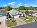 Desirable single-story home with two-car garage, lush landscaping, and well-kept lawn in a golf community at 5024 St Andrews Arc, Leesburg, FL 34748