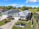 Inviting single-story home with a two-car garage, green lawn and landscaping, near a golf course at 5024 St Andrews Arc, Leesburg, FL 34748