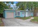 Cute light blue house with a beige garage and a brick walkway at 514 S Crystal Lake Dr, Orlando, FL 32803