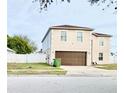 Two-story house with brown garage door and white fence at 5861 Windridge Dr, Winter Haven, FL 33881