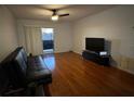 Living room with hardwood floors, a sofa, and a large TV at 912 Lake Destiny Rd # G, Altamonte Springs, FL 32714