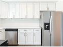 Modern kitchen with stainless steel appliances, white cabinetry, and white quartz countertops at 930 Lewis Dr, Daytona Beach, FL 32117