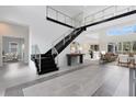 Modern two-story foyer with sleek staircases and glass railings at 9847 Laurel Berry Dr, Orlando, FL 32827