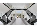 Elegant two-story entryway with a double staircase and modern light fixtures at 9847 Laurel Berry Dr, Orlando, FL 32827