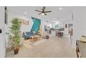 Open living room with teal accent wall, comfy seating, and view of kitchen at 1153 Seaside Mist Trl, Kissimmee, FL 34747