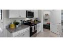 White cabinets, granite countertops, and stainless steel appliances at 1328 Hanoverian Dr, Lake Alfred, FL 33850