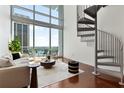 Bright living room with modern furniture, spiral staircase, and floor-to-ceiling windows with a stunning view at 150 E Robinson St # 1011, Orlando, FL 32801