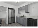 Gray cabinets, marble countertops and stainless steel appliances at 1527 Hernandes Dr, Orlando, FL 32808