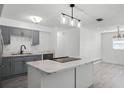 Modern kitchen with gray cabinets, marble countertops, and stainless steel appliances at 1527 Hernandes Dr, Orlando, FL 32808