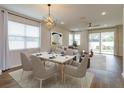 Open concept dining area with hardwood floors and modern light fixture at 2232 Donahue Dr, Ocoee, FL 34761