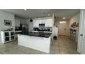 Modern kitchen with white cabinets, granite island, and stainless steel appliances at 3033 Timber Hawk Cir, Ocoee, FL 34761
