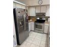 Stainless steel appliances and light tile floor at 310 Blue Jacket Ln, Orlando, FL 32825