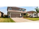 Two-story house with a two-car garage, landscaping, and palm trees at 351 Lazio Cir, Debary, FL 32713