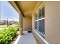 Covered front porch with neutral color scheme and a view of the neighborhood at 5080 Tana Ter, St Cloud, FL 34772