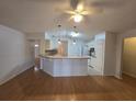 Bright living area featuring hardwood floors, a breakfast bar, and an open layout connecting to the kitchen at 770 Mink Ct, Poinciana, FL 34759