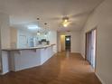 Bright living area featuring hardwood floors, a breakfast bar, and an open layout connecting to the kitchen at 770 Mink Ct, Poinciana, FL 34759