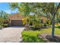Single-story home boasts a brick driveway and lush landscaping adding curb appeal at 800 Ebb Tide Ln, Kissimmee, FL 34759