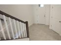 Bright entryway with tile flooring, white walls, a dark-stained wood railing, and a door with glass panel at 9088 Ocean Tide Way, Kissimmee, FL 34747