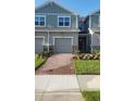 Inviting townhouse exterior with a well-maintained lawn and a brick pathway leading to the front entrance at 9088 Ocean Tide Way, Kissimmee, FL 34747