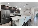 Modern kitchen with dark cabinetry, white countertops, and island seating at 11868 Pulitzer Pl, Orlando, FL 32832