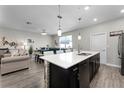 Open concept kitchen with island, dark cabinetry, and view to living room at 11868 Pulitzer Pl, Orlando, FL 32832
