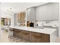 Modern kitchen with white cabinets, a large island, and wine storage at 16106 Pendio Dr, Bella Collina, FL 34756