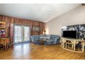 Inviting living room with wood paneling, French doors, comfortable seating, and wood floors at 221 Se 125Th Terrace Rd, Silver Springs, FL 34488