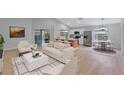 Bright living room with an open floorplan, modern furniture, and stainless steel appliances at 326 Morning Creek Cir, Apopka, FL 32712