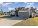 Front view of a gray one-story house with a two-car garage at 3829 Arborvitae Way, Deland, FL 32724