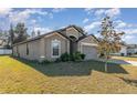 Side view of a gray one-story house with a two-car garage at 3829 Arborvitae Way, Deland, FL 32724