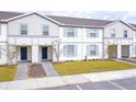Two-story townhouses with gray siding, blue shutters, and landscaped lawns at 4298 Lana Ave, Davenport, FL 33897