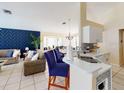 Open kitchen features a breakfast bar and modern appliances at 4715 Ainsdale Walk, Kissimmee, FL 34746