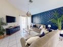 Spacious living area with a blue accent wall and comfy seating at 4715 Ainsdale Walk, Kissimmee, FL 34746