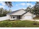 Attractive single-story home with a well-maintained lawn, an attractive neutral exterior, and a two-car garage at 10339 Castillo Ct, Clermont, FL 34711