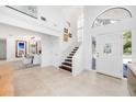 Bright foyer with tile floors, staircase, and art, with a view to a dining area at 11036 Schooner Way, Windermere, FL 34786