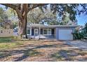Ranch home with screened porch and mature oak tree in front yard at 1246 Margina Ave, Daytona Beach, FL 32114