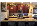 Modern kitchen featuring dark wood cabinets, granite countertops, and stainless steel appliances at 1517 Lancashire Way, Deland, FL 32720