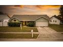 House exterior at sunset, featuring a two-car garage and front yard at 1747 Lady Slipper Cir, Orlando, FL 32825