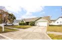 One story home with a green exterior, two car garage, and neatly landscaped yard at 1747 Lady Slipper Cir, Orlando, FL 32825