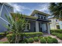 Two-story home showcasing a modern design, lush landscaping, and a welcoming entryway at 7901 Dausset St, Orlando, FL 32827