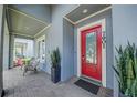 Elegant red front door welcomes you to this stunning home with a charming covered porch at 7901 Dausset St, Orlando, FL 32827