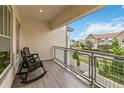 Relaxing balcony with gray wood-look floors and metal railing overlooking the neighborhood at 13444 Stoddart Ave, Orlando, FL 32827
