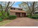 Two-story home featuring a two-car garage and a brick-paved driveway at 136 Woodmill Rd, Longwood, FL 32779