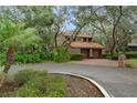 Two-story home with mature landscaping, a red tile roof, and a brick driveway at 136 Woodmill Rd, Longwood, FL 32779