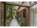 A quaint covered patio with tiled flooring, a bench, and garden views, perfect for relaxing outdoors at 136 Woodmill Rd, Longwood, FL 32779