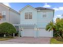 Light blue two-story house with a white pergola and two-car garage at 1400 Titian Ct, Reunion, FL 34747